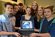 Schüler mit Laptop und Satellitenbildern