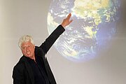 Holger Voigt zeigt auf Satellitenbild (Rohstoffwochen)