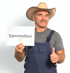Konny Reimann hält ein Schild mit der Aufschrift "Sammelbox" und den Daumen hoch