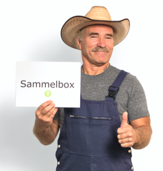 Konny Reimann hält ein Schild mit der Aufschrift "Sammelbox" und den Daumen hoch 