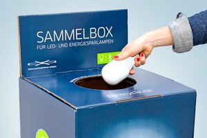 Frau legt Lampe in Sammelbox