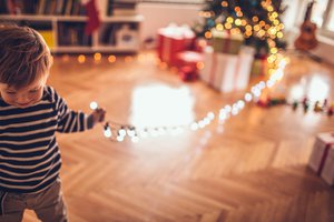Junge mit elektrischer Weihnachtsbeleuchtung