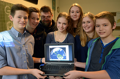 Schüler bei den Rohstoffwochen mit Laptop auf dem Satellitenbild der Welt gezeigt wird