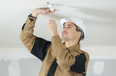 Foto eines E-Handwerkers, der gerade eine Leuchte montiert